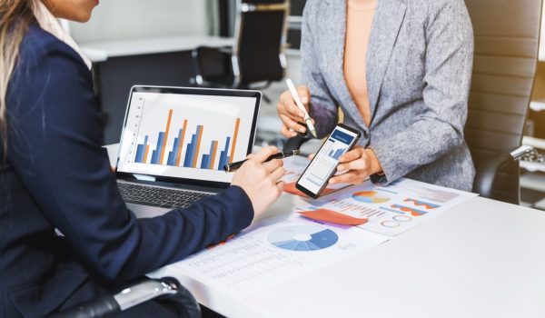 Two,Female,Business,Professionals,In,Suits,Sit,At,Desk,,Engaged