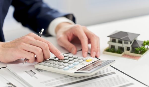 Businessman,Calculating,Money,Related,To,Real,Estate