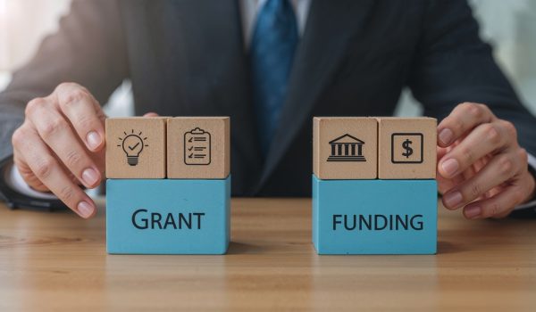 Man,Holding,Colorful,Blocks,With,Icons,And,Inscription,Grant,Funding.